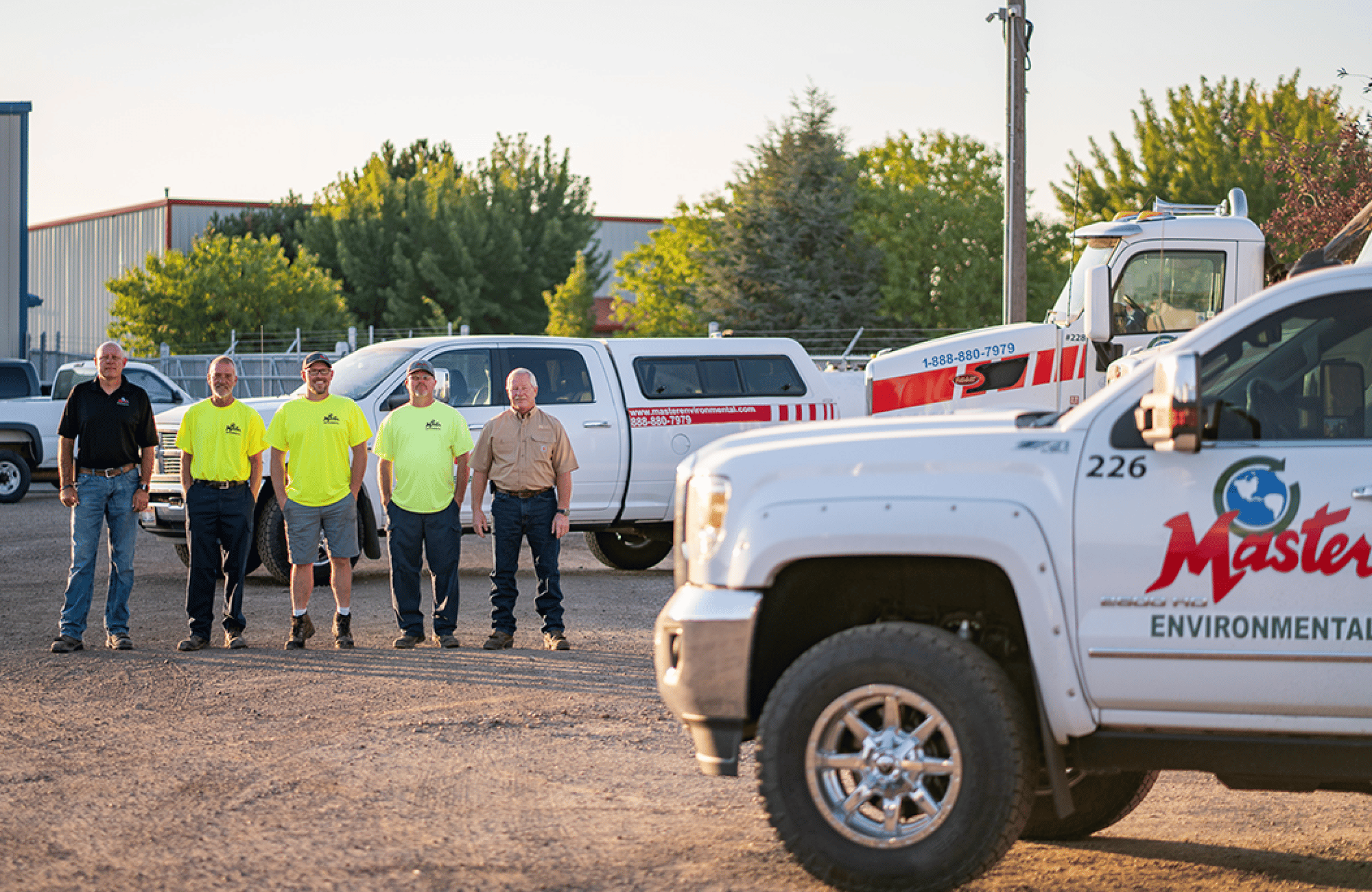 Master Environmental team standing in front of service trucks